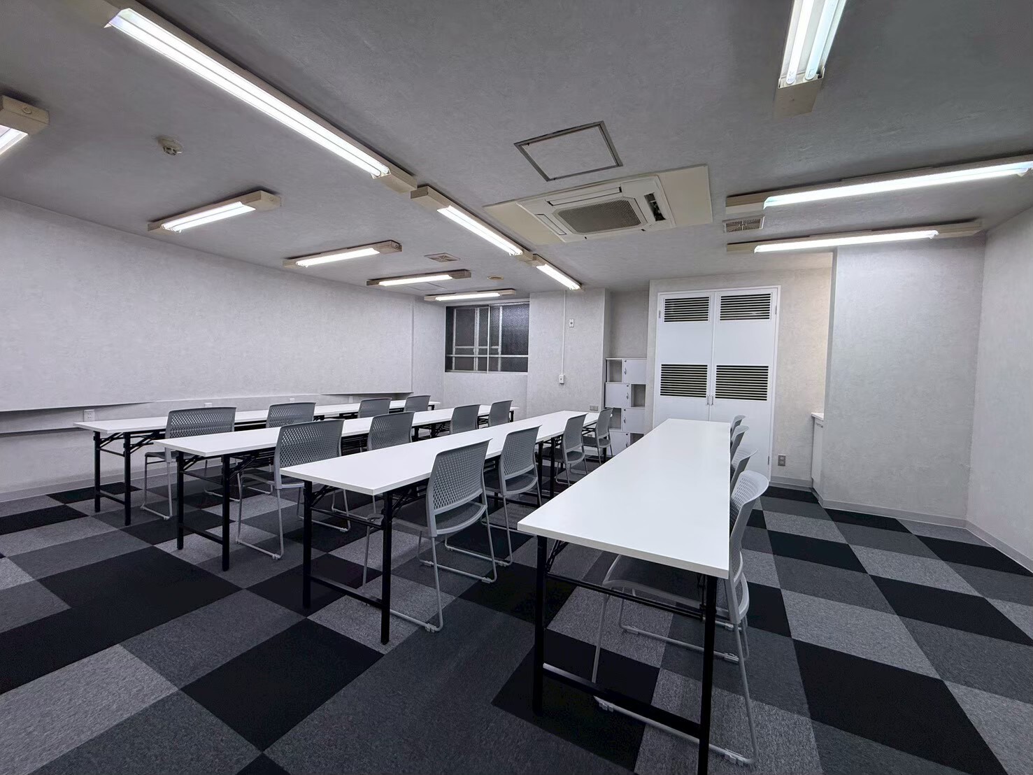 就労支援B型事業所の内装改修後に照明と作業机を整備した作業スペース